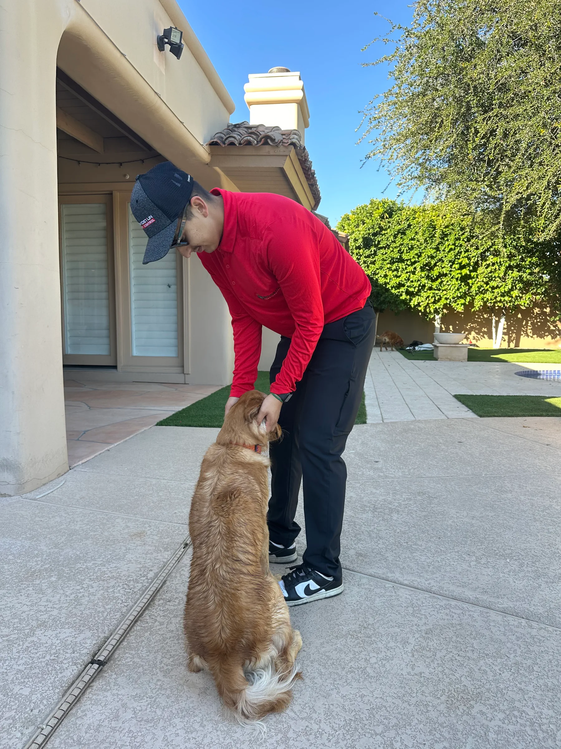 a Boydstun pest control technician playing with a dog
